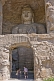 Image of Two western tourists looking at a giant Buddha statue at the Yungang Buddhist caves, near Datong.