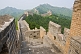Image of The Great Wall of China crosses forested mountain hillside.