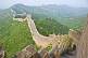 The Great Wall of China crossing forested hills and mountains.