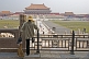 A cleaner watches tourists at the Hall of Supreme Harmony in the Forbidden City.