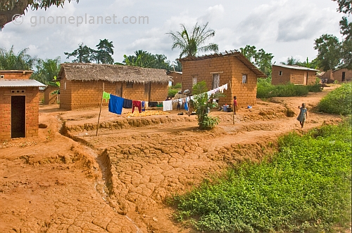 Small children and a line of drying laundry in front of mud-brick shacks and houses.