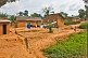 Small children and a line of drying laundry in front of mud-brick shacks and houses.