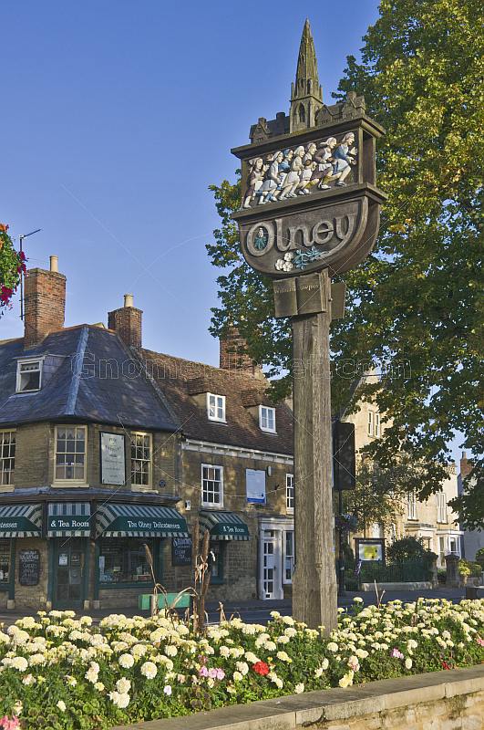 Wooden sign on Olney Market Square marks the annual pancake race first run in 1445.