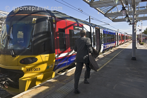 Man runs to catch train to Bradford on platform at Ilkley Railway Station.
