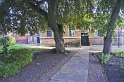 Quaker Meeting House with flagged stone path and beech trees.