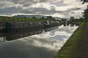 Narrowboats moored on the Leeds Liverpool Canal at Broughton Road on cloudy day.