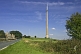 Image of The 330m 1080 feet high Emley Moor TV transmission tower dominates nearby road and houses.